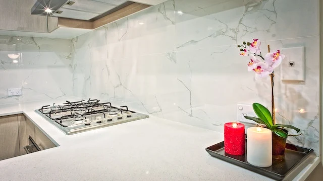 Cozinha com um vaso de orquídeas junto com duas velas branca e vermelha