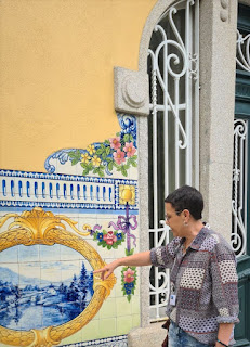 Guia brasileira no Porto apontando para um painel de azulejos