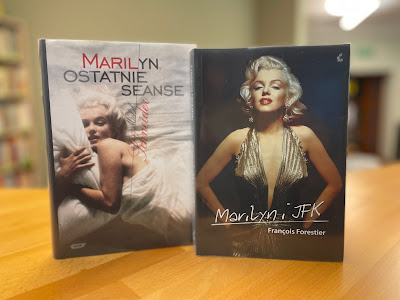 Na ladzie bibliotecznej ustawione są dwie książki dotyczące życia Marilyn Monroe.