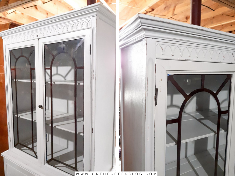 A creatively transformed hutch from Habitat For Humanity ReStore, repainted by Tiff in chippy white with red accents, showcasing a distressed finish and a blend of old and new charm. | on the creek blog // www.onthecreekblog.com