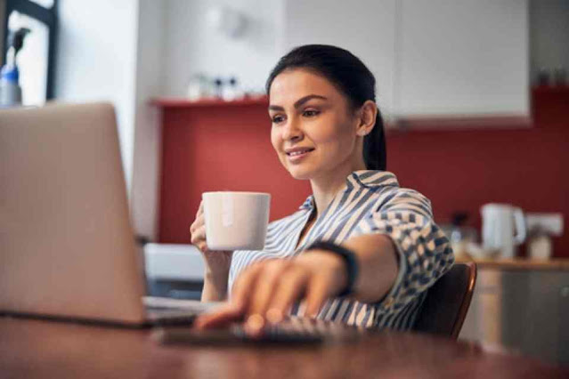 Calm pretty woman enjoying tea and using digital devices stock photo.