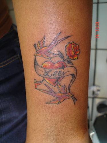 corazon tatuajes. En este tattoo vemos un corazon acompañado con una rosa y rodeado de dos 