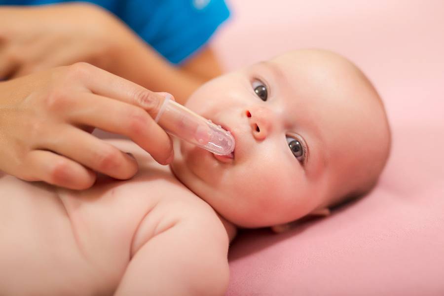 Mama cepillando los dientes de su bebe