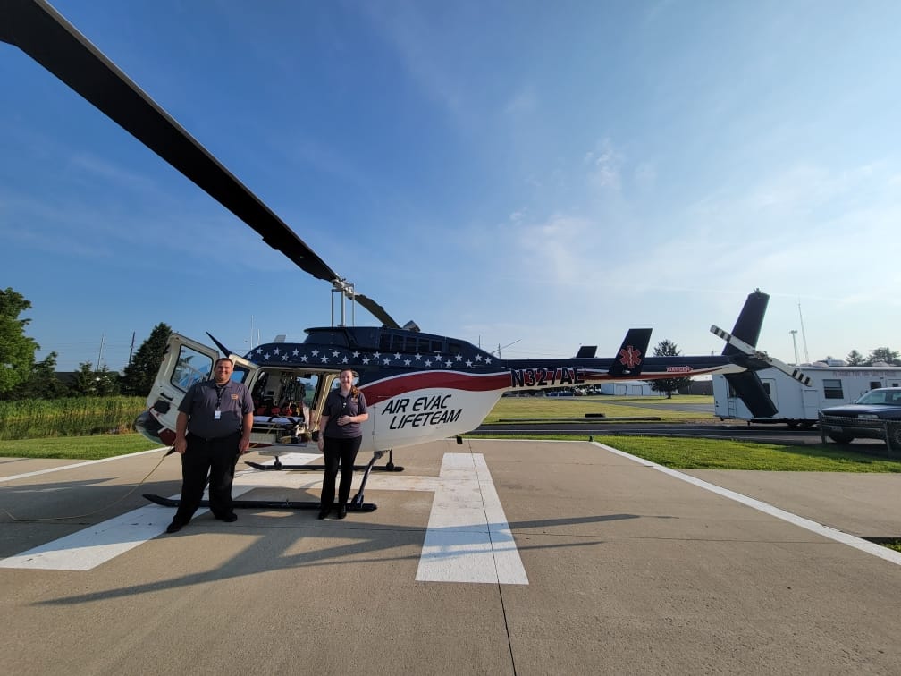 Dakota Parker and Makayla Clark in front of a helicopter