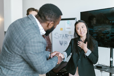 A man and a woman shaking hands to thank each other