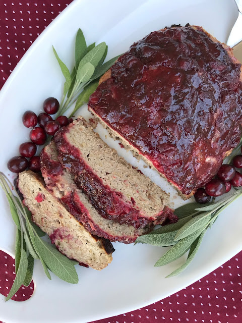 Serving platter with a sliced cranberry and brown sugar glazed meatloaf.
