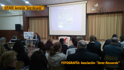 Un momento de la conferencia de María José Ruiz. En la imagen se ve a parte del público cómo hojea el trabajo de investigación que acaba de entregar la Presidenta de la Asociación 'Jerez Recuerda'  para su difusión.