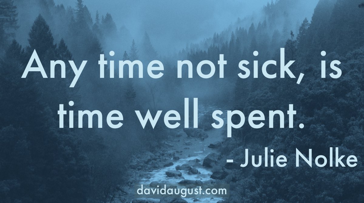 picture of a river through a wooded mountain area tinted blue with the words 'Any time not sick, is time well spent. -Julie Nolke' written on it