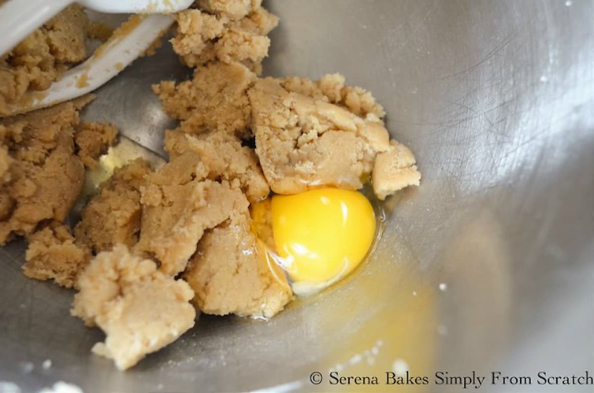 Eggs added to Peach Upside Down Cake batter in a stainless steel mixing bowl.