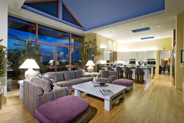 High ceiling living room with the kitchen in background