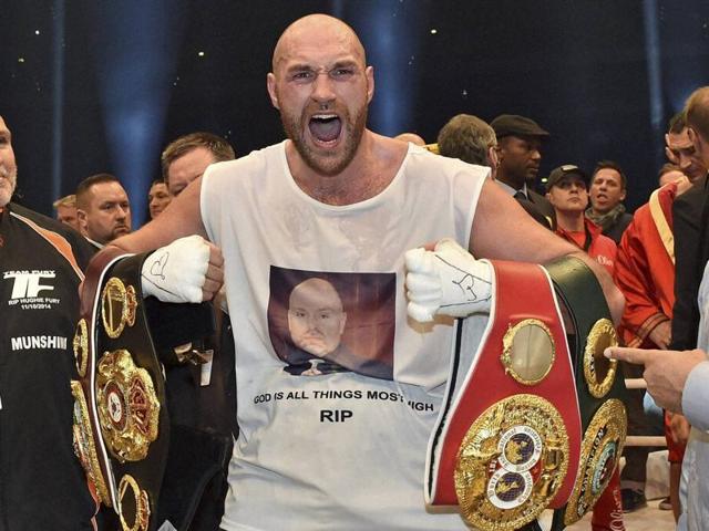 Britain's new world champion Tyson Fury celebrates with the WBA, IBF, WBO and IBO belts after winning the world heavyweight title fight against Ukraine's Wladimir Klitschko in the Esprit Arena in Duesseldorf, western Germany. (AP)