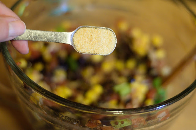 Garlic powder being added to the bowl. 