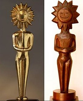 A foto mostra um kikito de bronze e o outro de madeira imbuia.