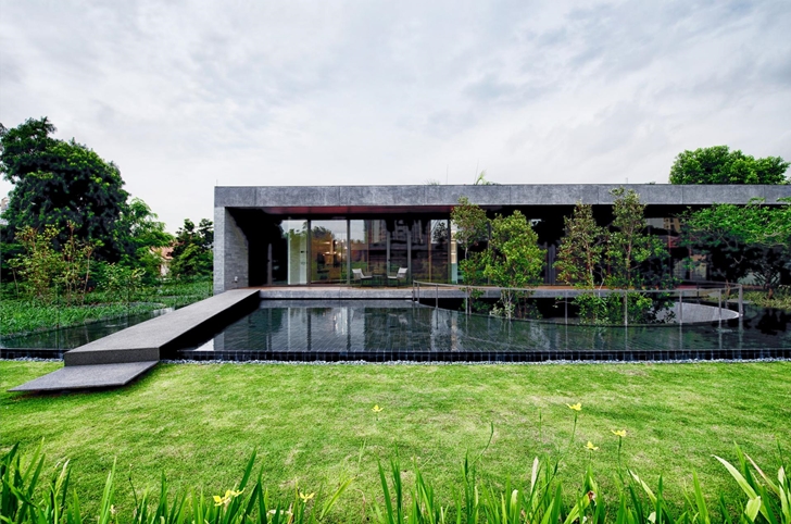 Shallow lake and bridge to The Wall House by FARM Architects