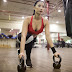 Strong determined ethnic woman stretching body using kettlebells