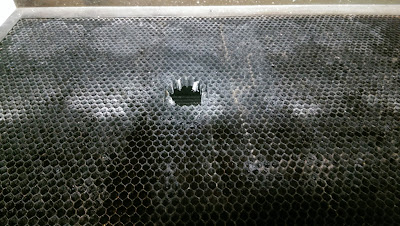 Hole burnt in the middle of a metal honeycomb grid