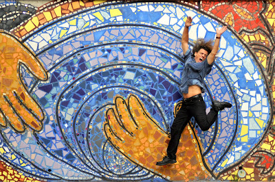 Foto hombre saltando frente a mural