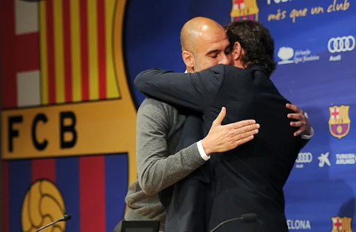 Barcelona president Sandro Rosell hugs departing coach Pep Guardiola