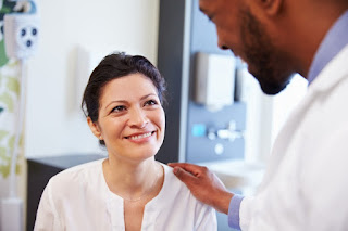 Doctor consoling patient with his hand on her shoulder