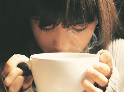 A girl hold a cup of water near her face