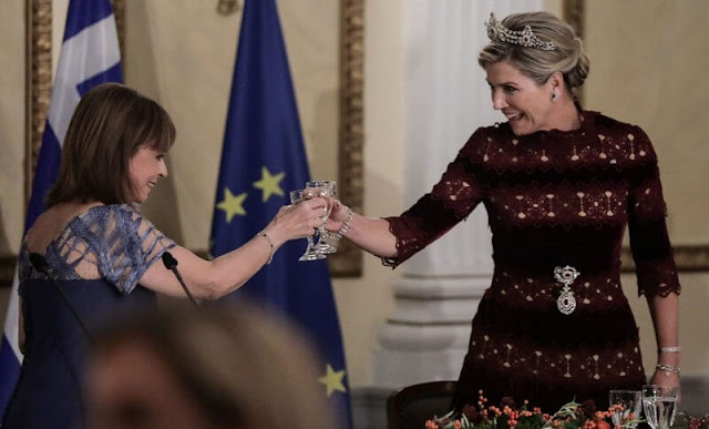Queen Maxima wore a burgundy Lissie silk velvet gown by Costarellos. President of Greece Katerina Sakellaropoulou