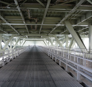 Looking along maintenance pathway under the Akashi Kaikyo Bridge. The pathway is perfectly straight and disappears into the distance