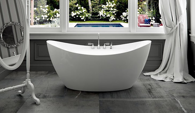 Large whirlpool freestanding tub in a white and gray bathroom.