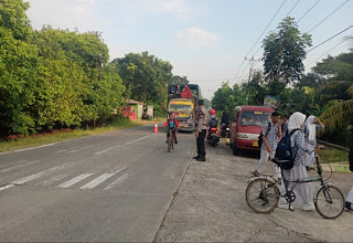 Personil Polsek Wonosalam Membantu Pengaturan Dan Penyebrangan di Depan SMP 1 Wonosalam