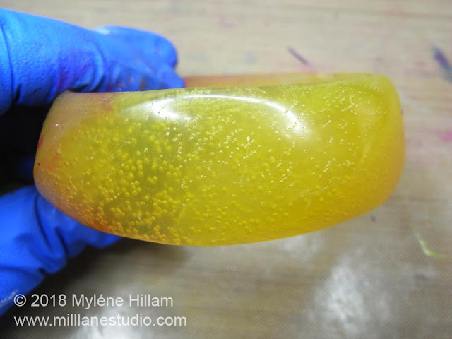 Translucent yellow resin bangle filled with bubbles.