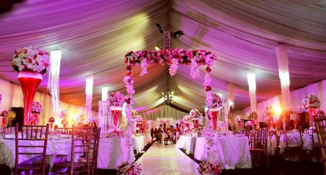 charming-purple-Nigerian-Traditional-Wedding-Decor-under-giant-tent-square-dining-table-arrangement-with-tropical-flowers