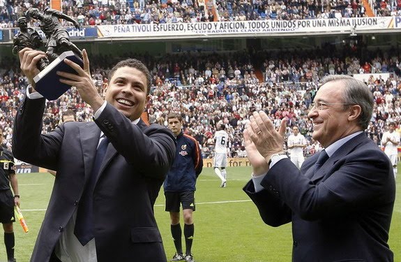 Ex-Real Madrid striker Ronaldo holds up a trophy next to president Florentino Pérez