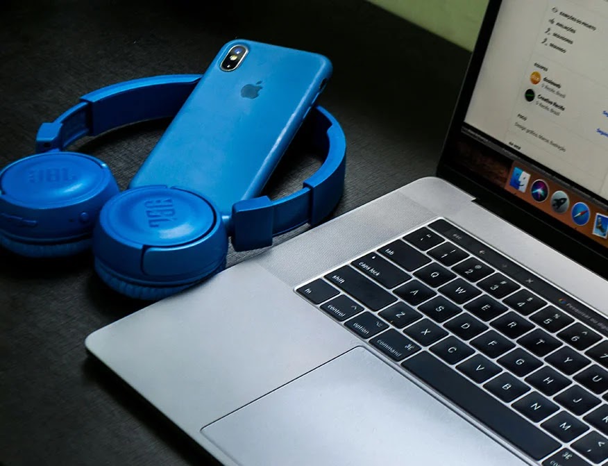 macbook-pro-al-lado-de-auriculares-inalambricos-azules