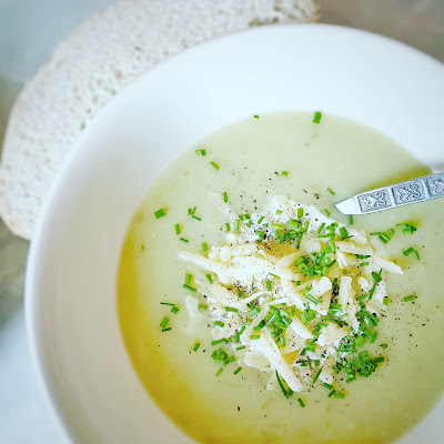 Leek and potato soup in a dish with a spoon and slice of bread