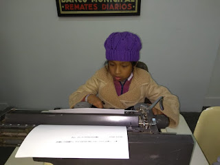 se observa una alumna escribiendo en la vieja máquina de escribir
