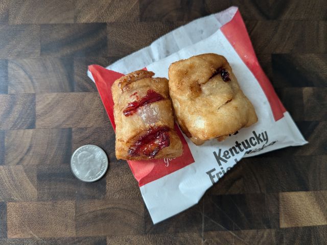 Two KFC Cherry Pie Topper next to a quarter.