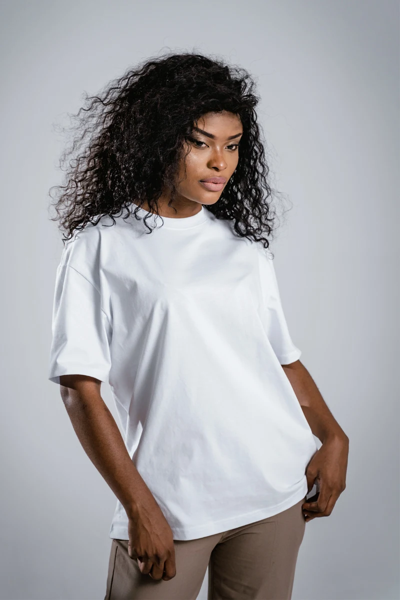 young woman in white t-shirt is posing in a studio