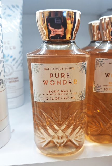 3 BBW Pure Wonder Body Washes on shelf w/ 2 moisturizing ones in white packaging, multi-colored pastel glittery snow blossoms