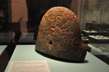 Wyobrażenie nordyckiego boga Lokiego na kamieniu do miecha kowalskiego. Eksponat znajduje się w muzeum Moesgård w Århus. 