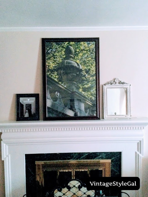 Sparsely decorated mantel with mirror and pictures