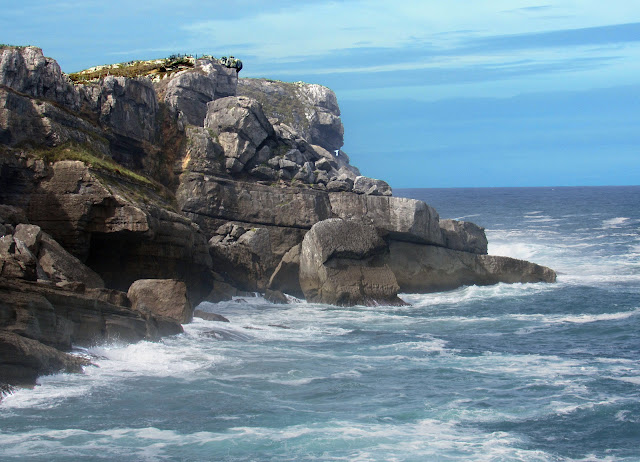 Al pie del acantilado se ve una roca que asemeja mucho a las cabezas de la Isla de Pascua.