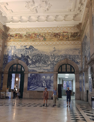 Estação de São Bento do Porto e painéis de azulejos e 5 pessoas a circular no atrio