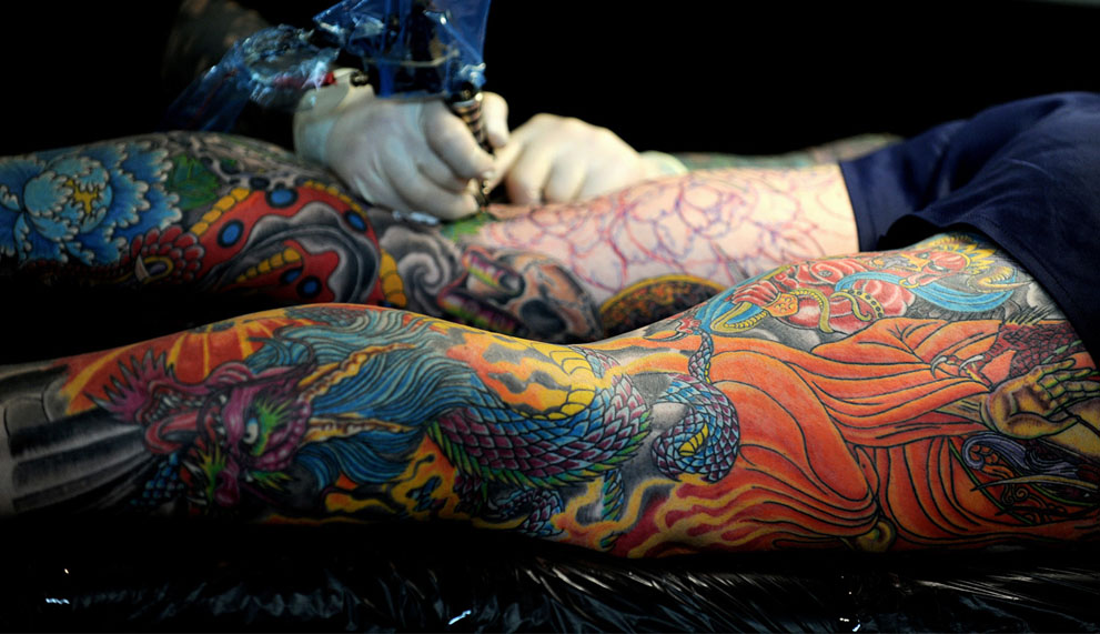 A man has his leg tattooed during the third Sydney Tattoo and Body Art Expo