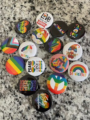 The Pride pins that Aunt Emily got Elizabeth for her birthday. They are all in a pile on the kitchen island.