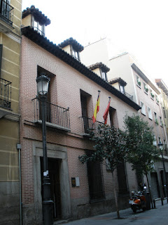 Edificio de ladrillos y zócalo de piedra, Tres sencillos balcones en la planta superior y ventanas en la buhardilla.