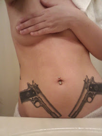 two gun tattoo on stomach witt piercing on navel