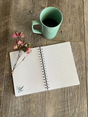 Diario con una flor y una taza de café