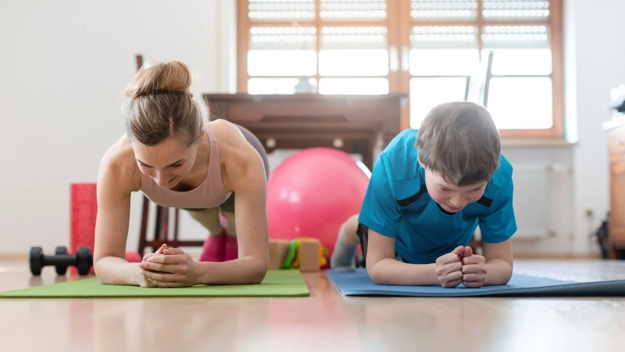 Family in self quarantine during covid-19 crisis staying fit at home exercising in the living room.