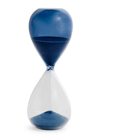 hourglass, half blue and half clear, with blue sand