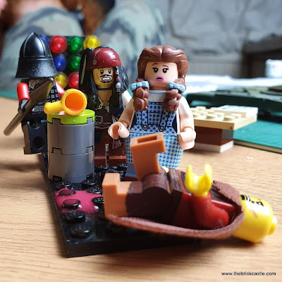 LEGO scene where a knight has knocked over a drink, and Min the Merciless has slipped in it.