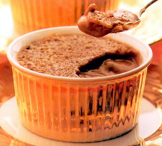 Indulgent dessert of a mango and chocolate custard topped with caramelized sugar and served in a gold dish.